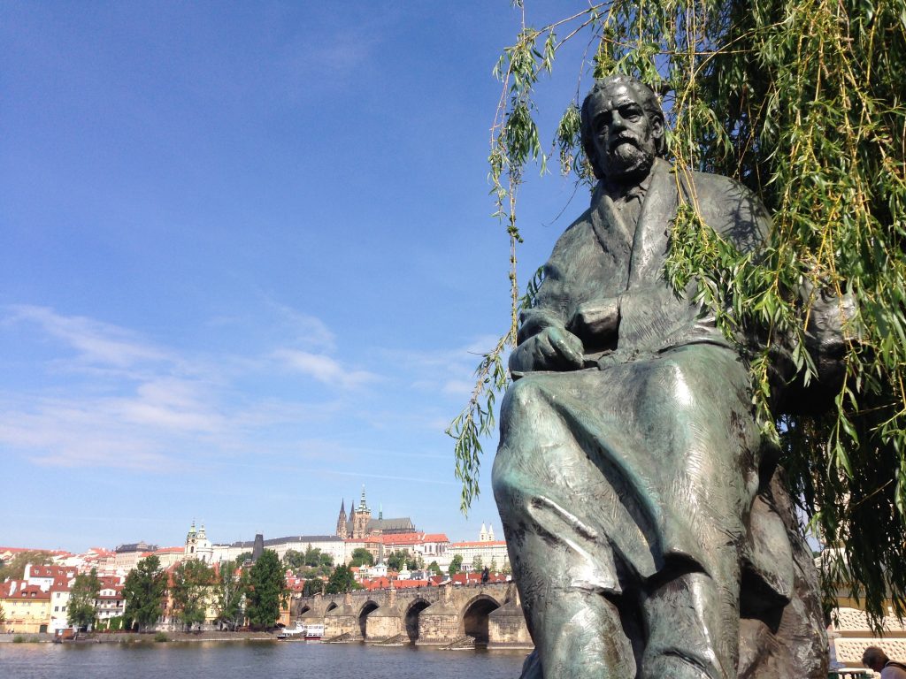 Statue of Bedrich Smetana in Prague next to Vltava river and Charles Bridge